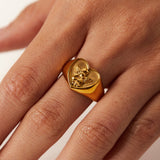 Anillo grueso de acero chapado en oro con ángel y corazón