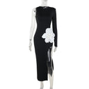 Vestido negro de mujer con abertura alta y detalle de flor